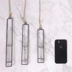 Three hanging glass candle holders on a marble surface with a smartphone for scale.