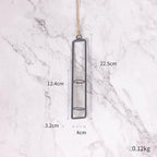 Hanging glass vase with measurements on a marble background