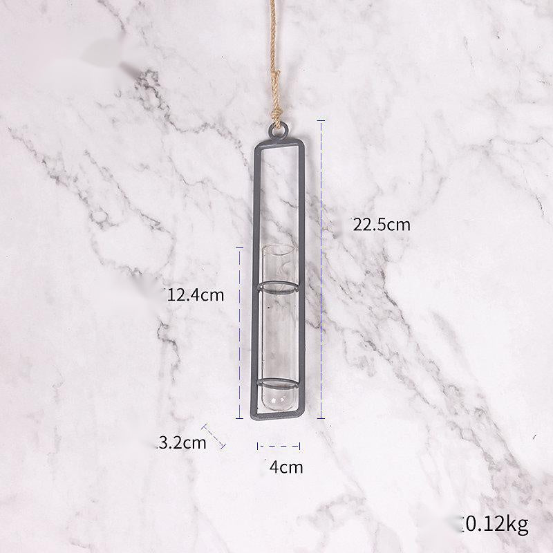 Hanging glass vase with measurements on a marble background