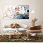 Modern living room with a floral painting, white sofa, and brown chair.