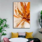 Abstract painting with orange and beige colors on a wall above a sofa.