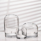Three clear glass vases of different sizes on a light background