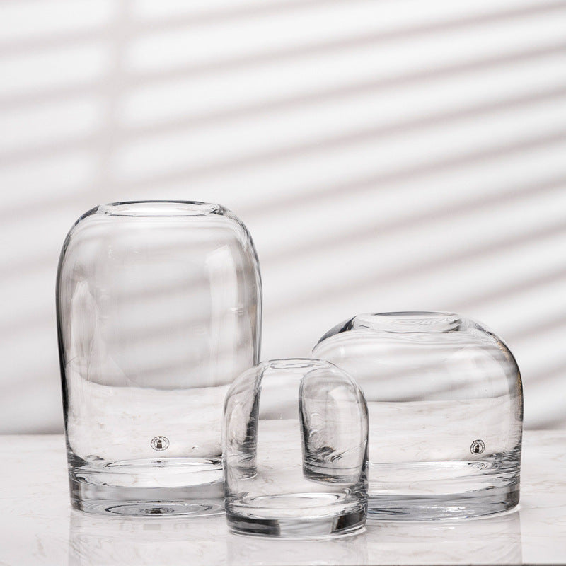 Three clear glass vases of different sizes on a light background