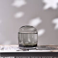 Clear glass vase on a surface with a blurred background