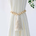 Curtain tieback with wooden beads and tassel on a white curtain