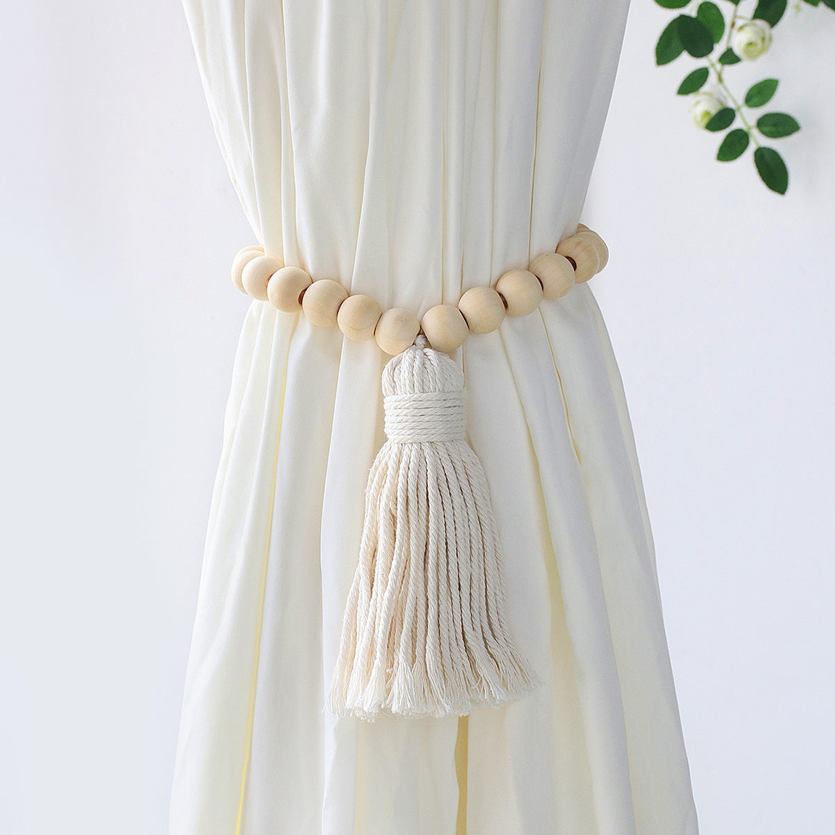 Curtain tieback with wooden beads and tassel on a white curtain