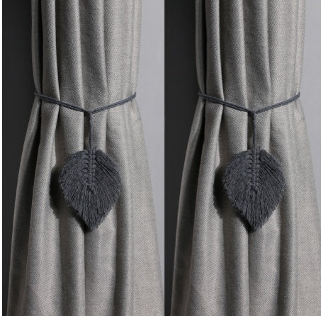 Gray curtains with decorative heart-shaped tiebacks against a plain background