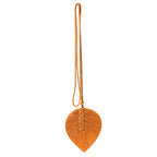 Orange leaf-shaped pendant with a string on a white background