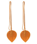 Pair of orange leaf-shaped earrings with strings on a white background