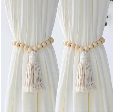 Curtains with wooden bead and tassel tiebacks on a white background