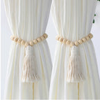 Curtains with wooden bead and tassel tiebacks on a white background
