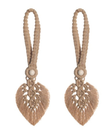 Pair of beige macrame earrings with heart-shaped designs on a white background