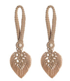 Pair of beige macrame earrings with heart-shaped designs on a white background