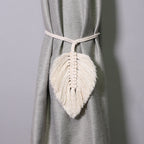 Macrame leaf tassel curtain tieback on a gray curtain against a gray background
