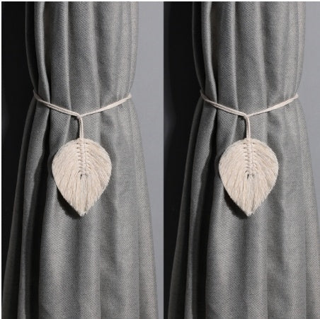 Gray curtain with leaf-shaped decorative tiebacks on a gray background