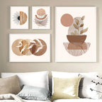 Set of four abstract art prints on a wall above a sofa with decorative pillows.