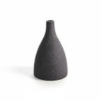 Black textured vase on a white background with measurement lines.