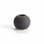 Black spherical vase on a white background with measurement lines.