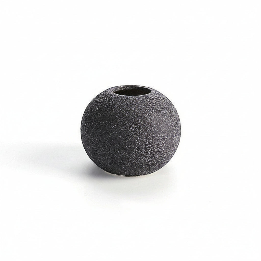 Black spherical vase on a white background with measurement lines.