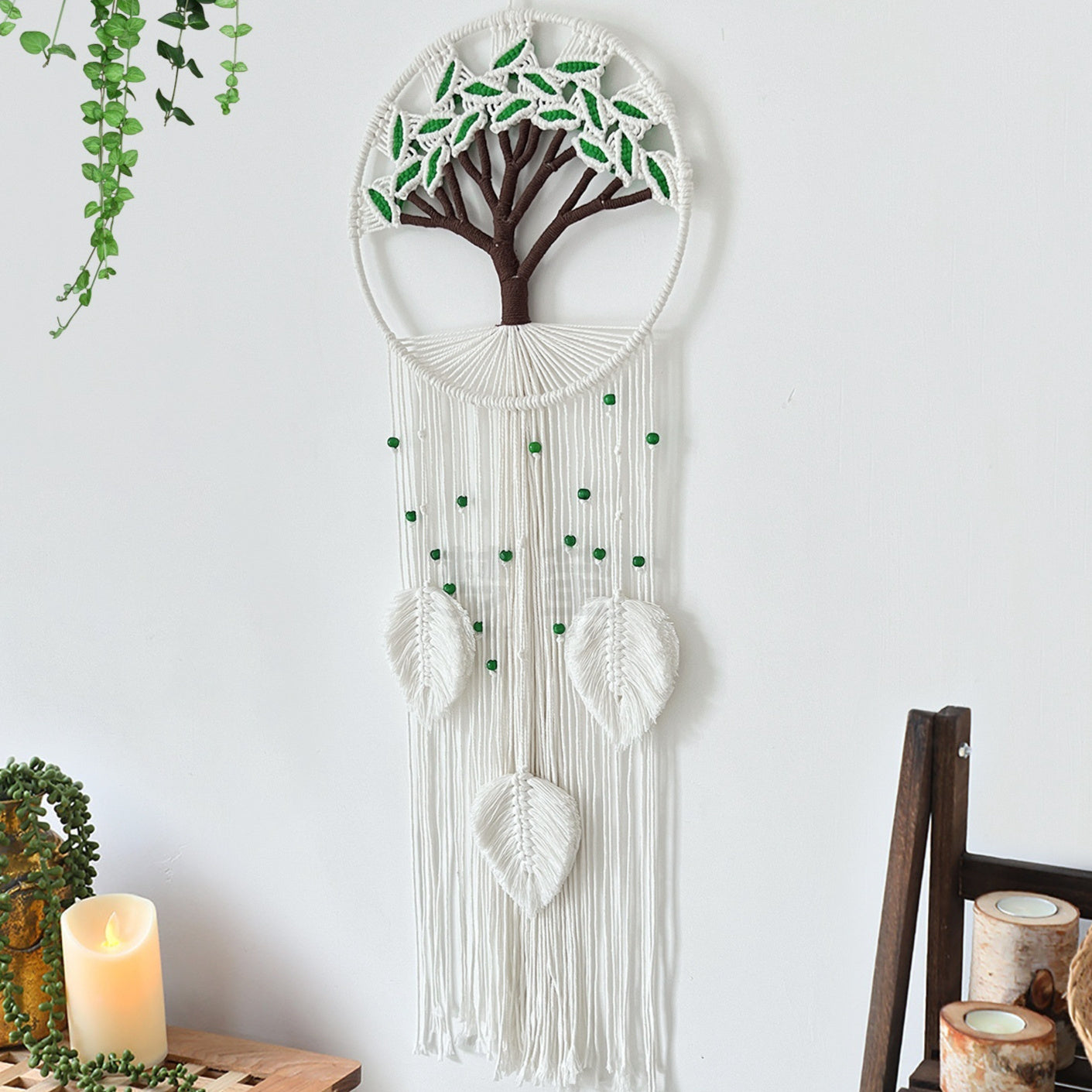 Decorative wall hanging with tree design on a white wall.