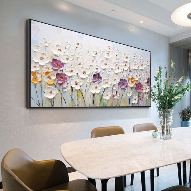 Floral painting on a wall above a dining table with chairs.