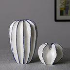 Set of two white ceramic vases featuring blue-trim leaf-like contours
