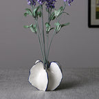 Small sculptural ceramic vase with organic folded shape and blue trim