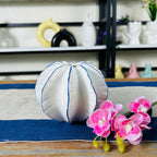 Compact white vase with wavy sculpted form and deep blue edges