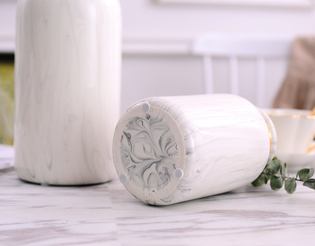 Blue-and-white marbled ceramic vases with gold detailing displayed together