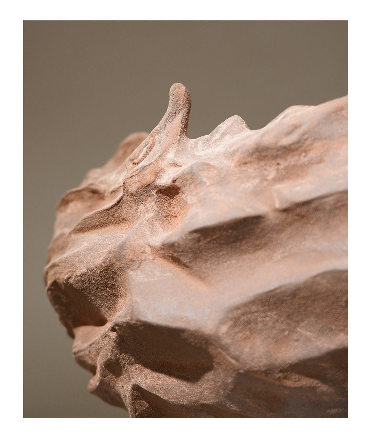 Close-up of a textured ceramic or stone object with a brown background. Modern Brick - Nordic Ceramic Table Vase.