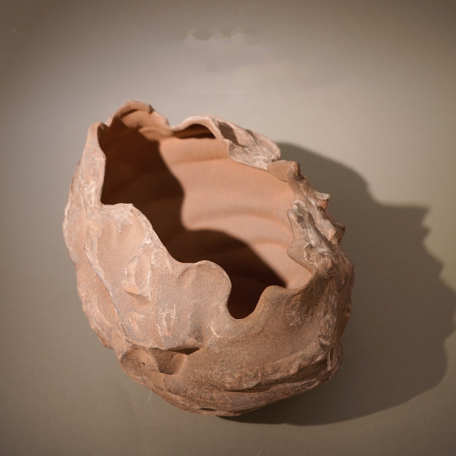 Terracotta pot with a textured surface on a plain background