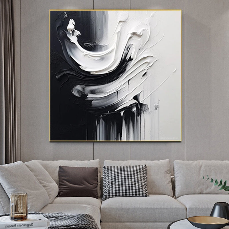Abstract black and white painting on a wall above a sofa with decorative pillows.