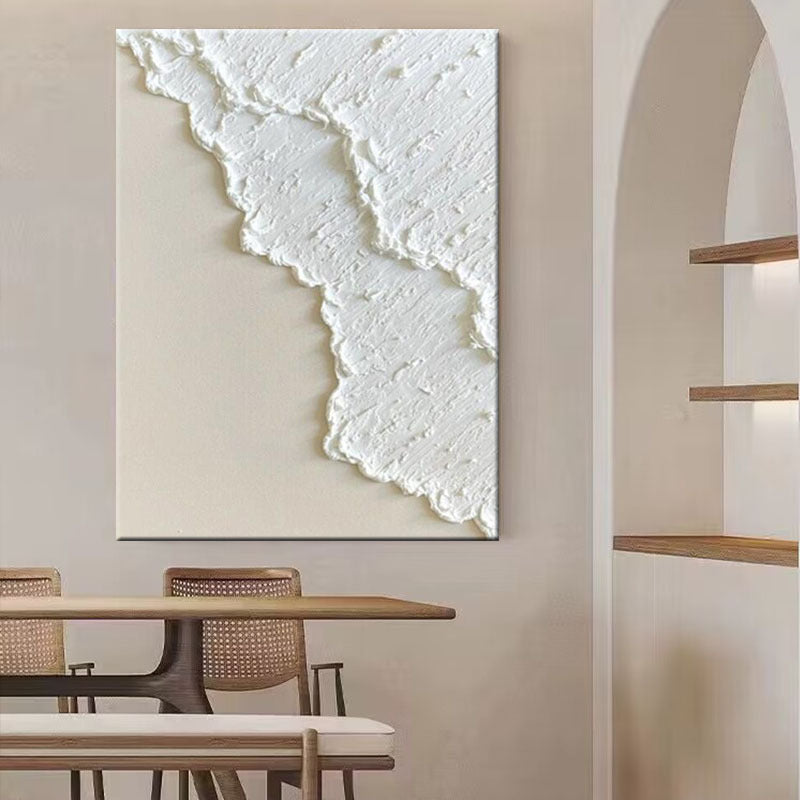 Abstract white artwork on a beige wall above a wooden dining table.