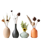 Four vases in different colors with decorative elements on a white background