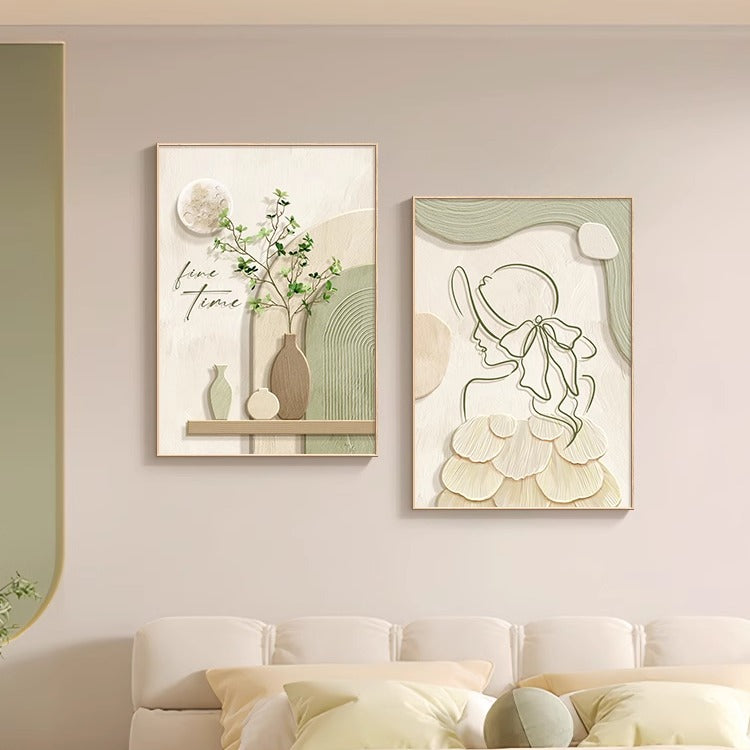 Two framed artworks on a wall above a sofa in a living room setting.