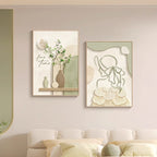 Two framed artworks on a wall above a sofa in a living room setting.