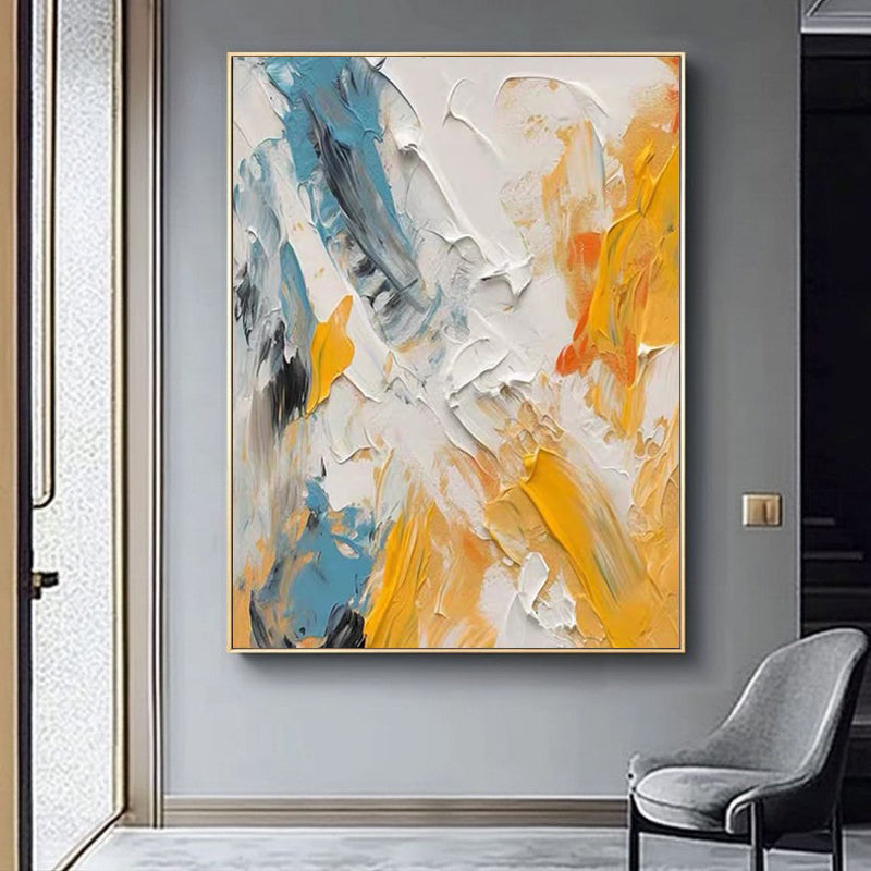 Abstract painting with blue, orange, and white colors on a gray wall.