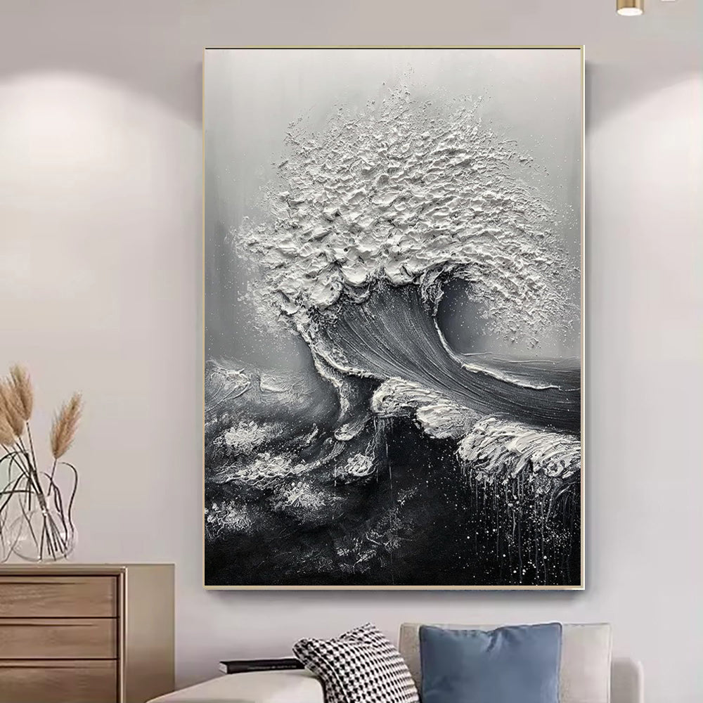 Black and white wave painting on a wall above a sofa