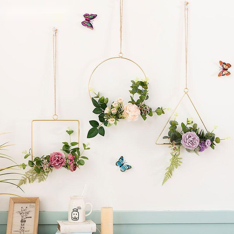 Decorative wall art with floral wreaths and butterflies on a light blue wall.