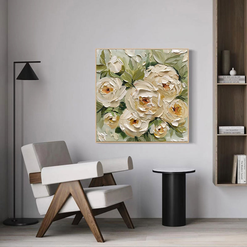 Floral painting on a wall above a chair and table in a room.