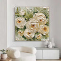 Floral painting on a wall above a white armchair and cabinet.