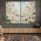 Two floral paintings hanging on a wall above a wooden console table.